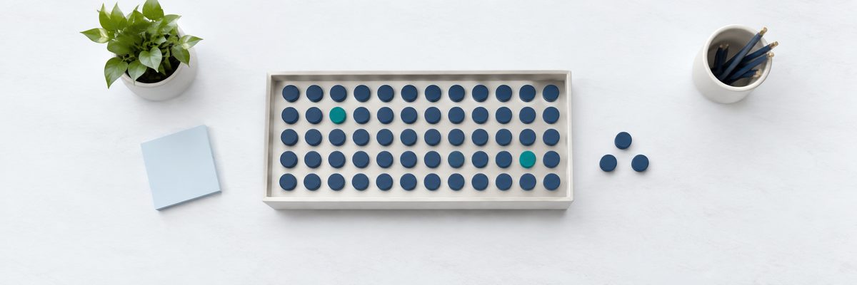 A tray of tokens in neat rows, a few lifted out